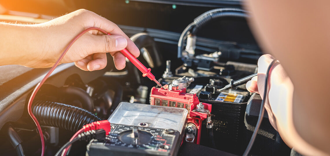 Subaru service technician inspecting a battery