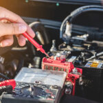 Subaru service technician inspecting a battery